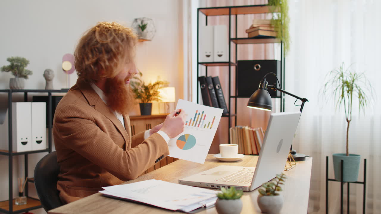 Businessman working on laptop at home office desk talks on online communication webcam video call