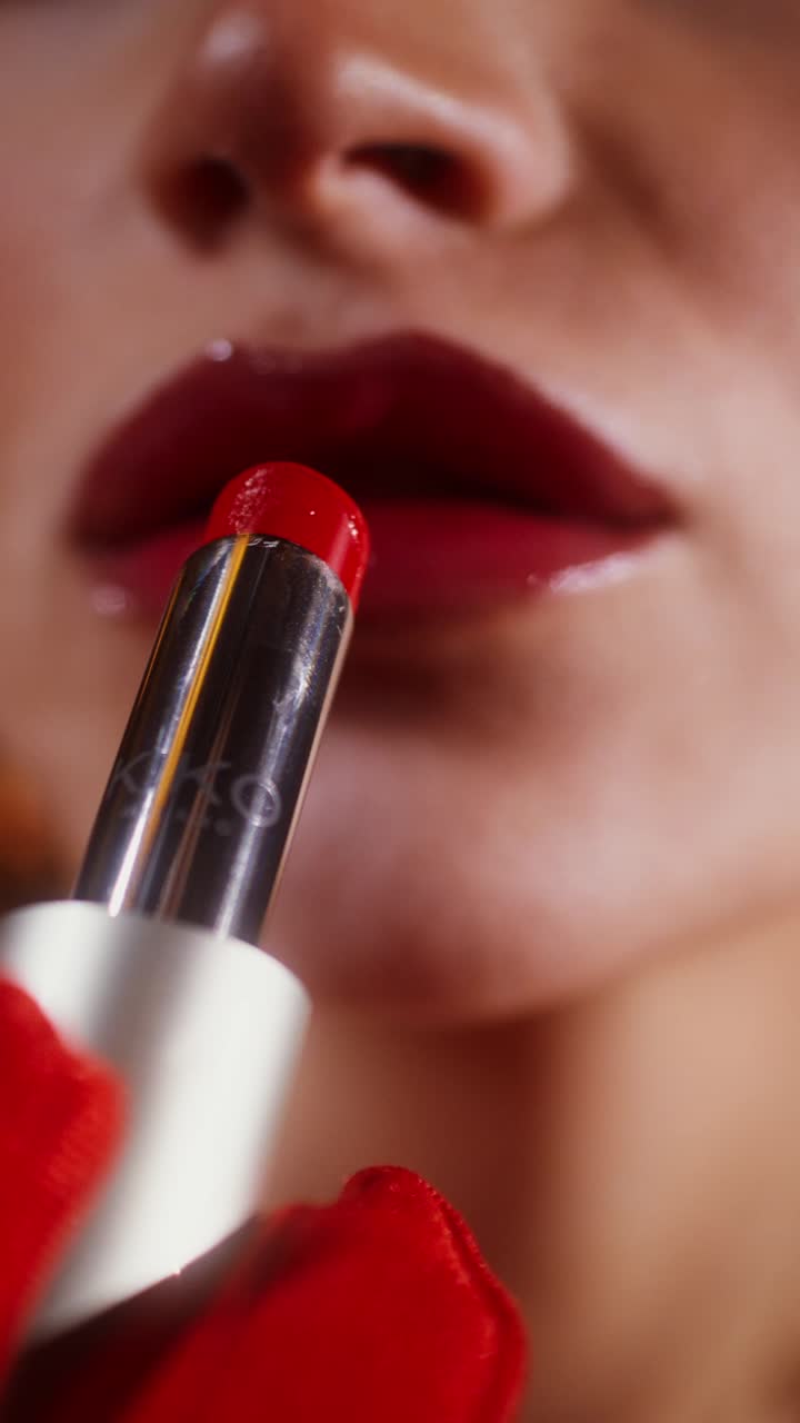 mujer aplicar lápiz labial rojo