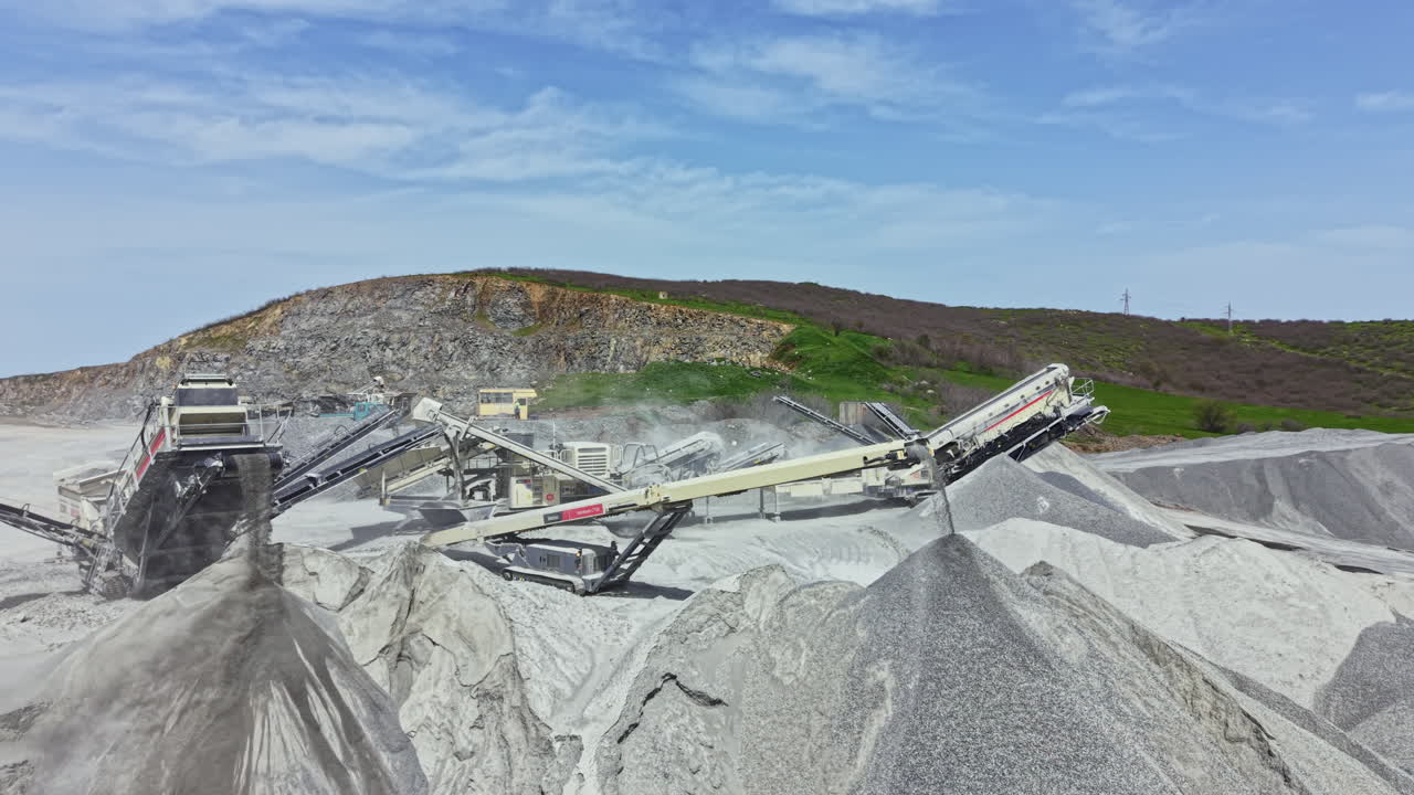 Granite quarry operations with heavy machinery working under a clear sky