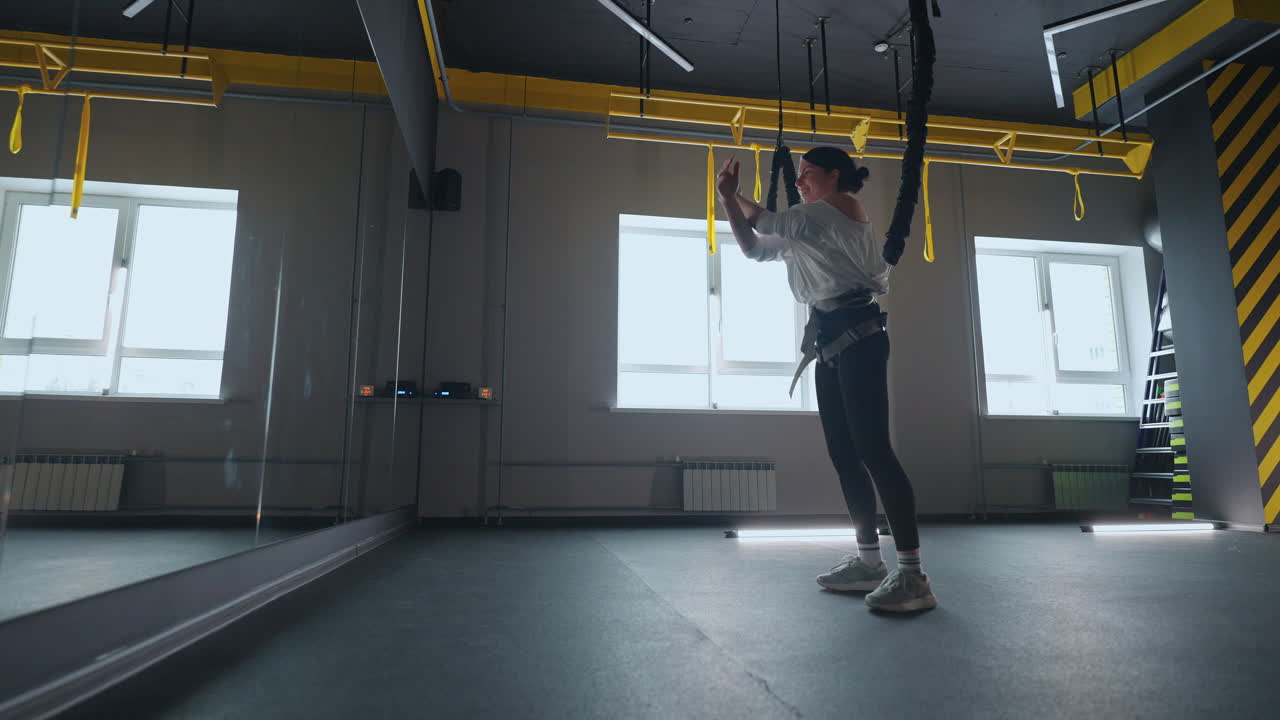 근력 훈련 장비 를 사용 한 실내 운동 여자 가 매달려서 푸시업 을 하고 있는 건강 한 생활 방식