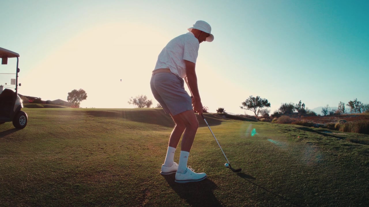golfer hitting wedge pitch shot in extreme slow motion at sunset, perfectly clipped short game wide angle 4k 800fps twilight