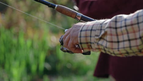 close-up of a hand holding a fishing rod and reel