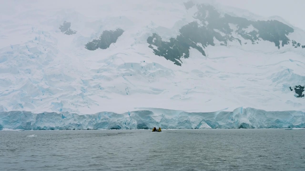Bote Zodiac acercándose a un imponente glaciar en la Bahía de Flandes, Antártida - Plano general