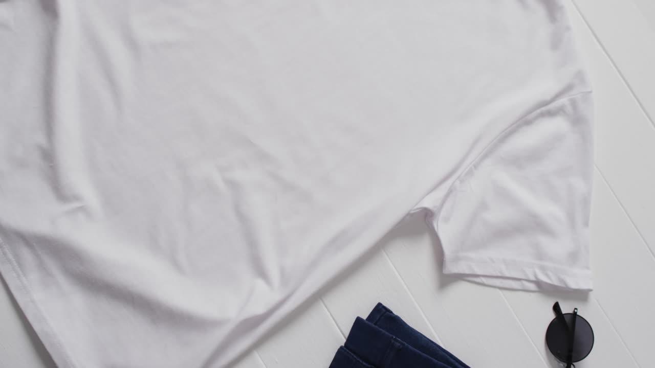 Video of flat lay of white t shirt with copy space on white background