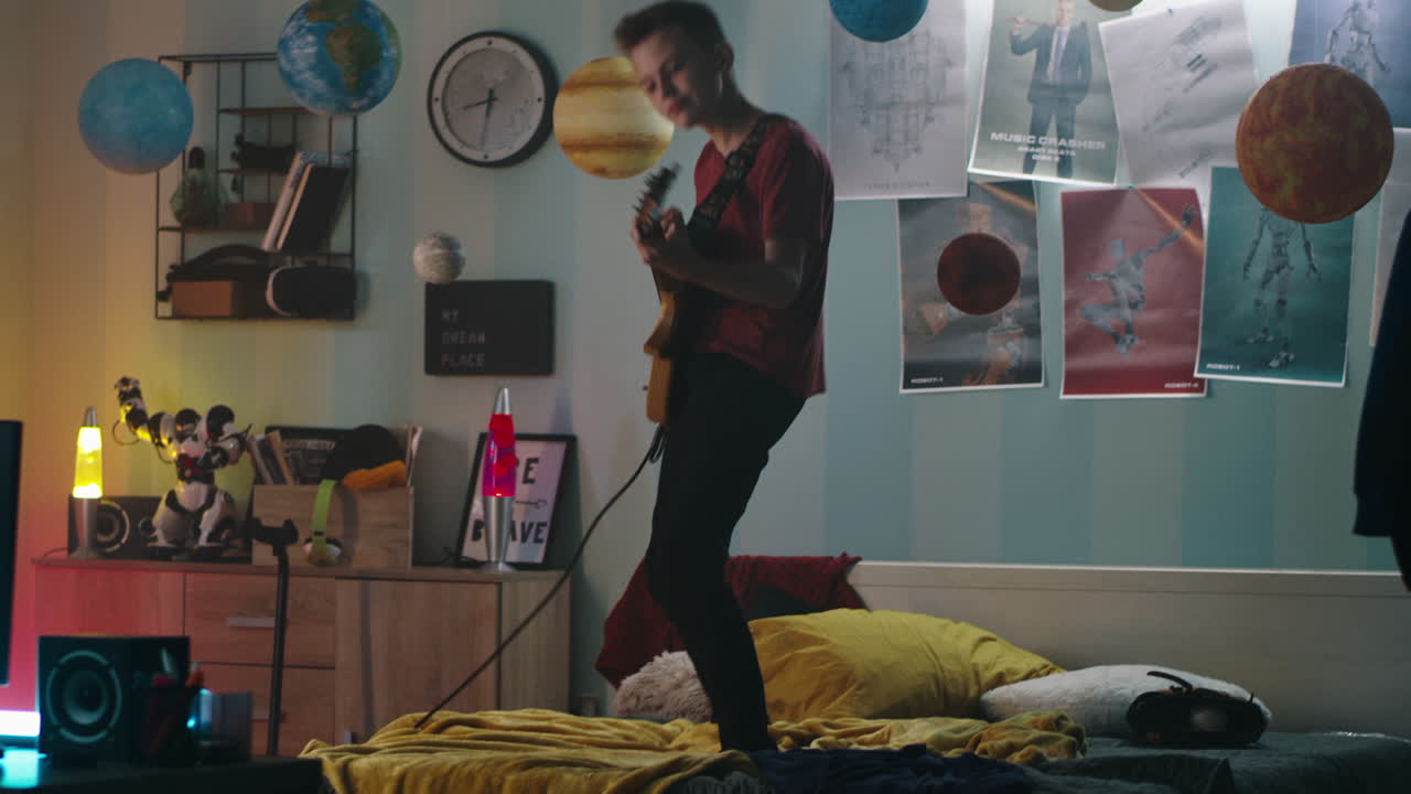 Teenage Boy Playing Electric Guitar in His Bedroom