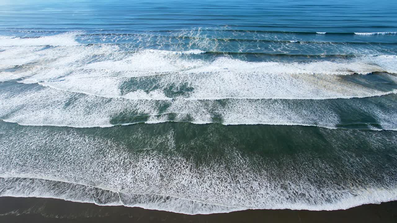 4K aerial drone shot looking down on ocean tide at Seaside, Oregon beach