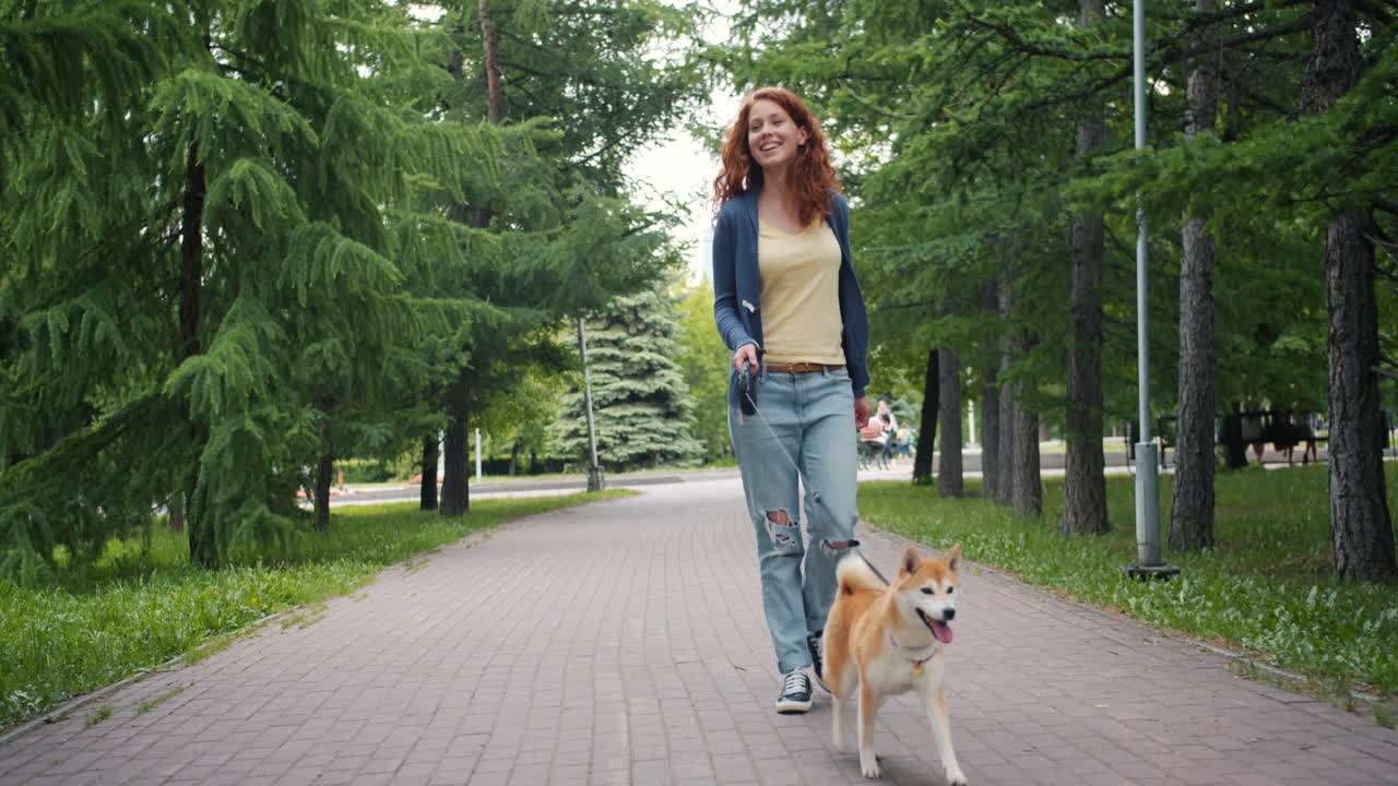mujer paseando a un perro en un parque
