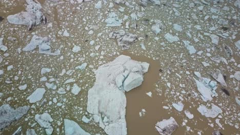 Icebergs-float-in-muddy-glacier-lagoon-in-Iceland