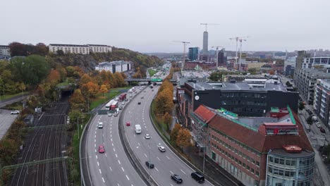 Vehicles-Travelling-At-E6-Road-Next-To-Empty-Train-Tracks-Going-South-And-East-In-Gothenburg,-Sweden