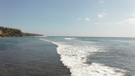 Low-flyover-fisherman-in-middle-of-ocean-next-to-hidden-beach-in-Bali-Indonesia