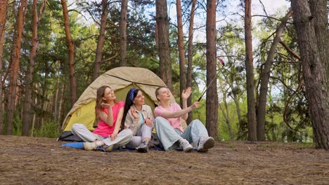 happy friends taking a selfie in a forest during camping trip