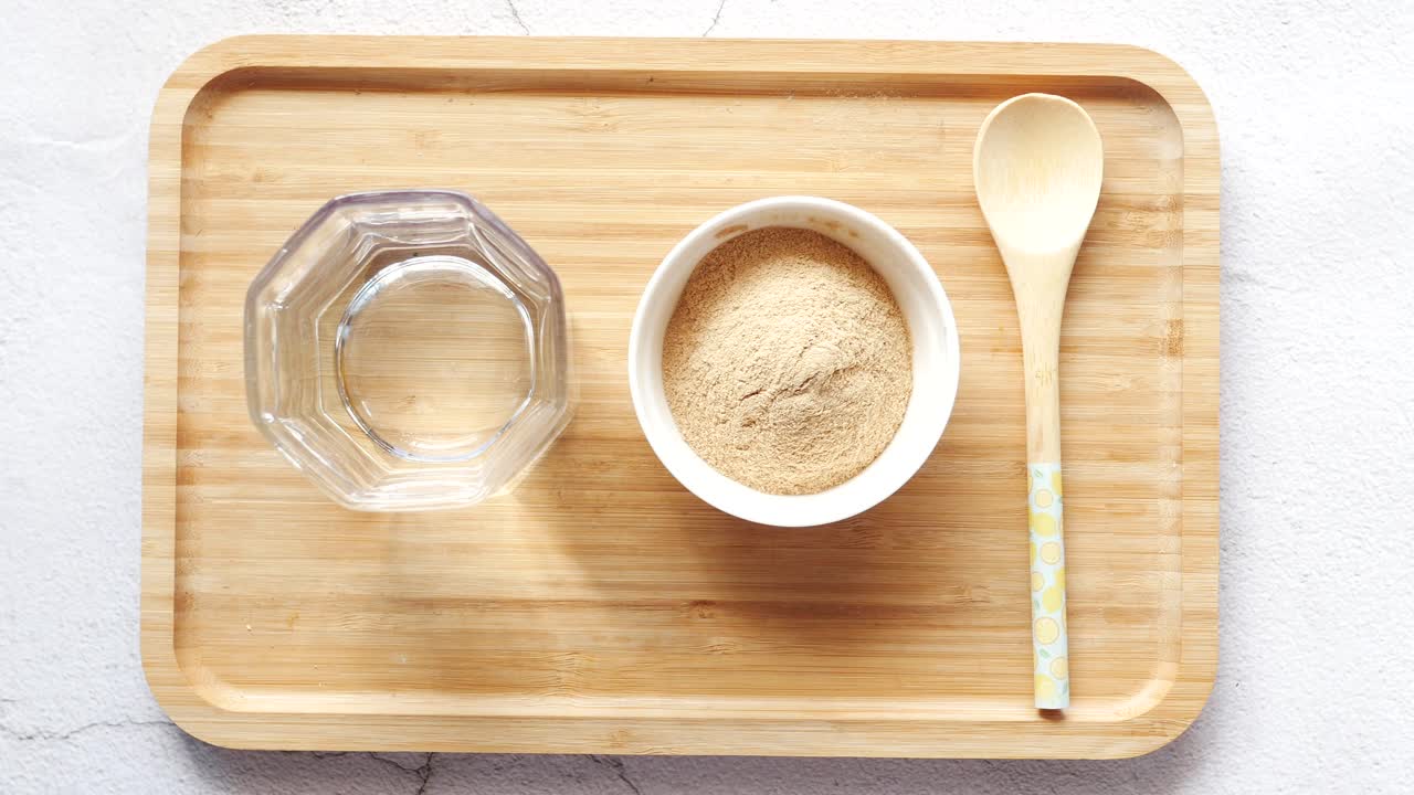 Powder in Bowl with Water and Spoon on Tray
