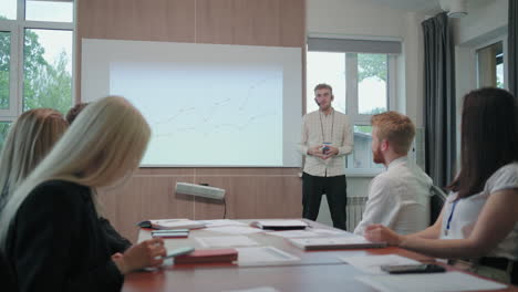 male-IT-specialist-is-presenting-his-report-in-meeting-with-with-colleagues-in-conference-hall