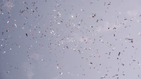 confetti and small danish flags against a blue sky