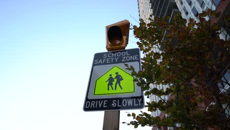 Yellow-School-Safety-Zone,-Drive-Slowly-sign-flashing,-close-up-during-day