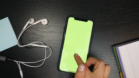 smartphone with green screen and chroma key. businesswoman is chatting on cellphone. woman is using digital smartphone with green screen. office desk background