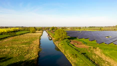 Luftaufnahme-Eines-Großen-Solarparks-Neben-Einer-Ruhigen-Landschaft-Und-Einem-Kleinen-Fluss