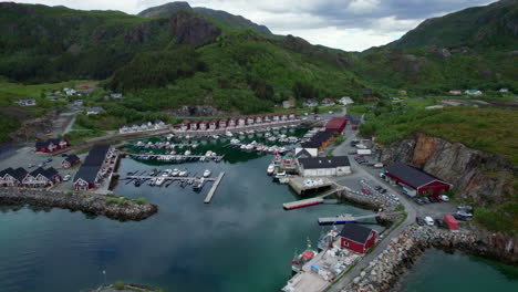 Toma-Aérea-Hacia-Atrás-De-Un-Puerto-Deportivo-Noruego-En-Helgeland,-Toneladas,-Nubes-Reflejándose-En-La-Superficie.