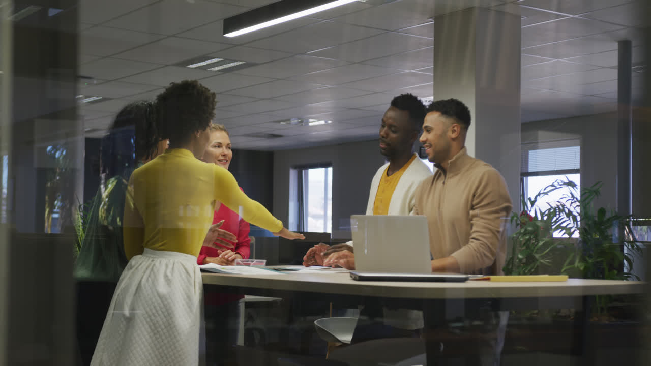 Happy diverse male and female business colleagues teaming up in office