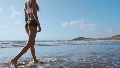 chica camina por la playa y en el agua