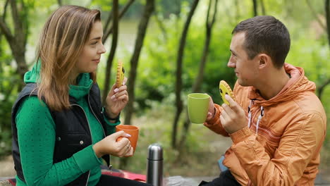 Happy couple drinking black tea together outdoors in nature
