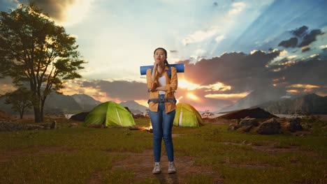 woman trekking and camping at sunset