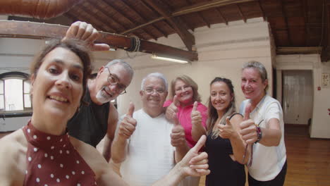 Senior-woman-taking-photo-with-friends-after-dance-class-and-everybody-gives-thumb-up