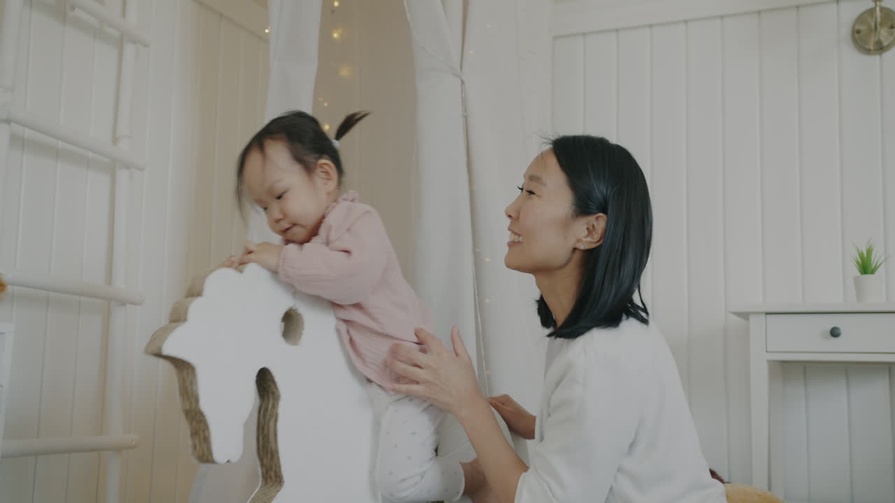 Mother and Daughter Playing with Rocking Horse