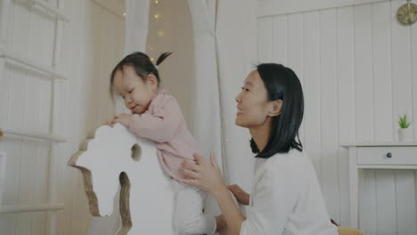 mother and daughter playing with rocking horse