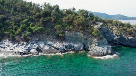 Vista-De-Arriba-Hacia-Abajo-Sobre-Un-Acantilado-Junto-Al-Mar-Con-Pequeñas-Playas-Aisladas,-Aguas-Cristalinas-Y-Vegetación-Verde-Cerca-De-La-Isla-De-Gramvousa,-Isla-De-Thassos,-Grecia,-Europa