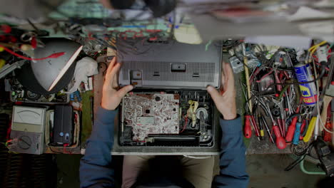 fotografía aérea de manos arreglando viejos equipos electrónicos en un taller