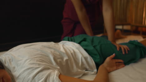 una mujer caucásica se relaja con un masaje tailandés en el spa. mujer asiática en tradicional murió realiza masaje en la espalda.