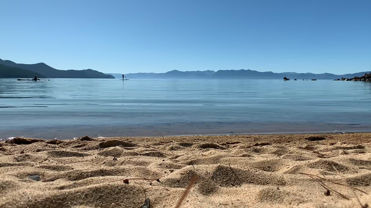 네바다 주 인클라인 빌리지의 샌드 하버 주립 해변에서 카약과 패들 보딩을 즐기는 사람들의 실루엣