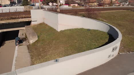 Drone-aerial-of-a-young-male-Parkour-traceur-running-across-an-urban-landscape