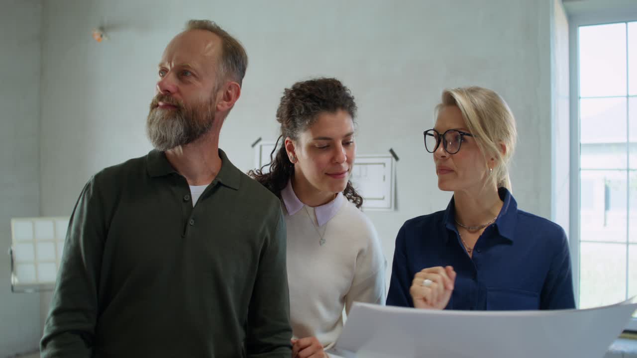 los propietarios y los contratistas revisan los planes de construcción