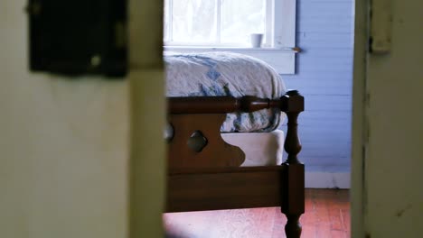 Smooth-left-to-right-dolly-shot-that-reveals-a-vintage-wooden-bed-being-bounced-and-shaking-suggestively-from-activity-on-the-bed