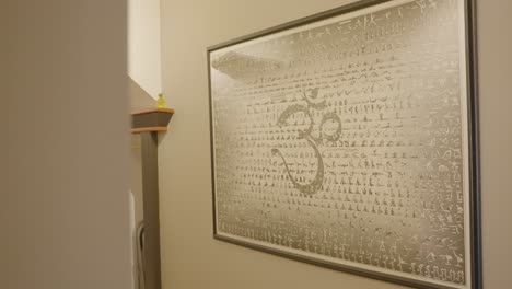 la pared está decorada con una pieza de arte con varias posturas de yoga y un símbolo prominente que representa el yoga