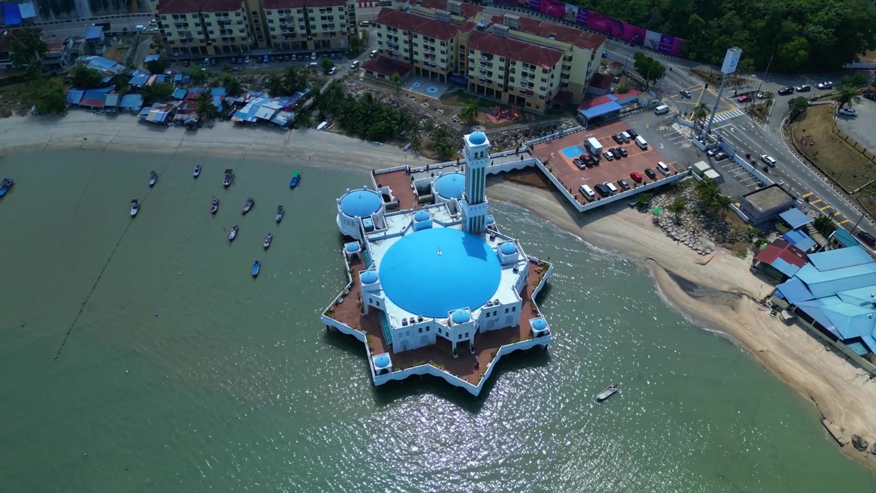 Sultan Ahmad Shah-moskeen flydende på vandet med omkringliggende både og lejlighedsbygninger i Tanjung Bungah, Penang. Magisk luftfoto fra dronekamera, der peger nedad.