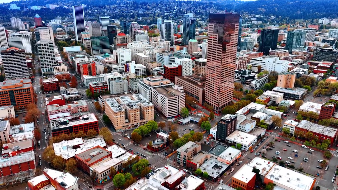 Paesaggio urbano variegato di Portland, Oregon, USA. Riprese con drone sulla città di giorno. Area popolata sulle montagne sullo sfondo.