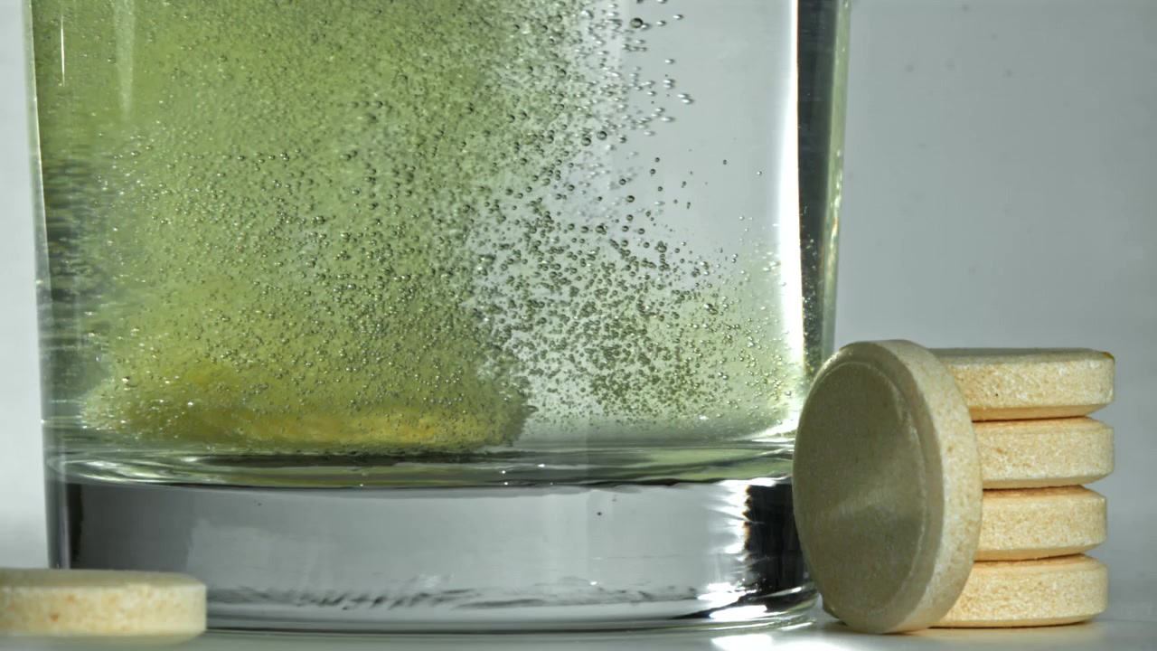 Tavoletta effervescente che si dissolve in un bicchiere d'acqua