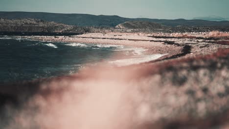 strong waves hit the gravel beach at the bjornnesbukta, foaming and splashing on the stones