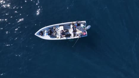 Enge-Vogelperspektive-Auf-Fischer,-Die-An-Einem-Sonnigen-Tag-Ein-Boot-Im-Offenen-Meer-Arrangieren