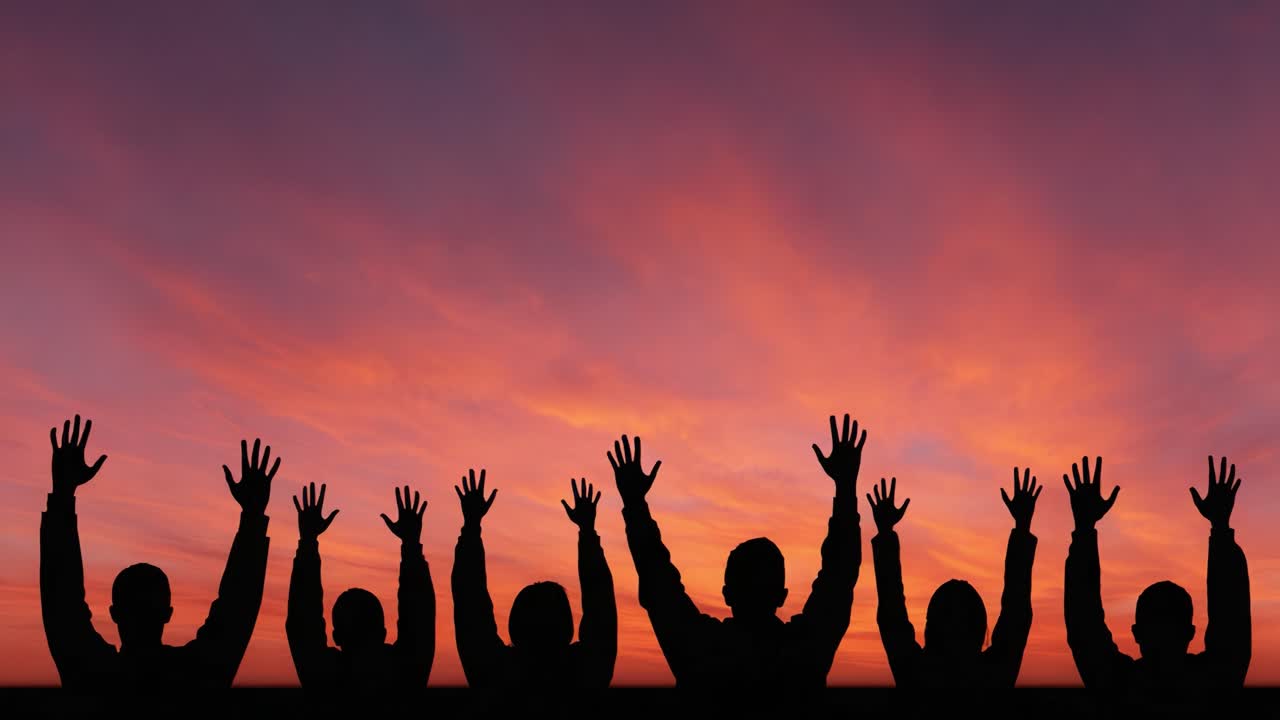 A Powerful Silhouette Against a Vibrant Sunset: Celebrating Unity and Expression Through Raised Hands in a Stunning Sky