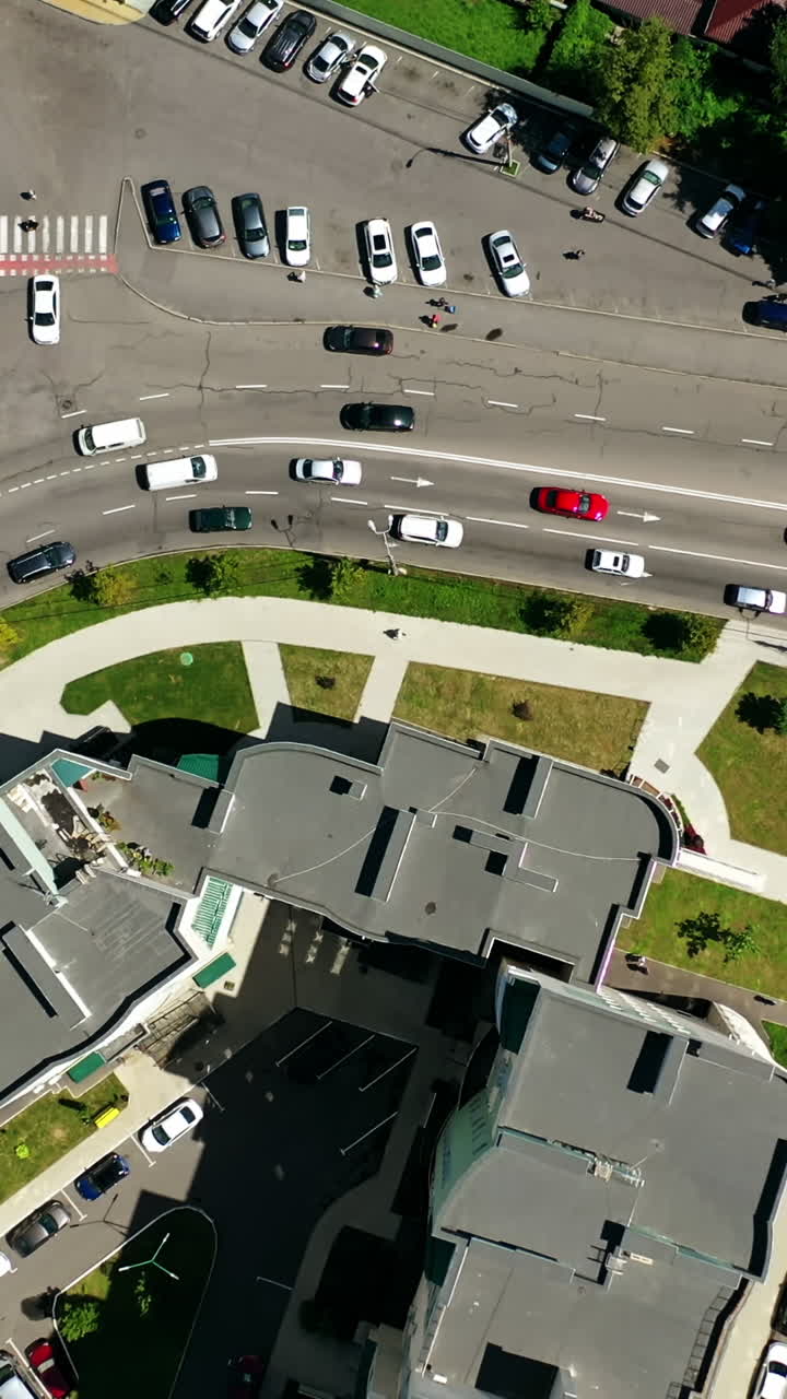Traffic in the city. Cars moving and standing on parking zone in modern city. Car traffic and parking concept. City filled with cars. City ecology. Aerial view. Vertical video