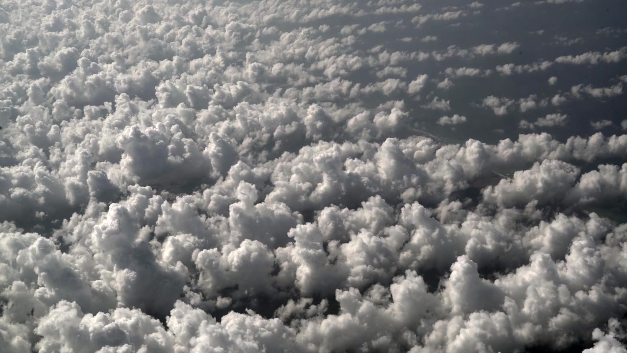 Aerial View of Dense White Clouds From Airplane Window