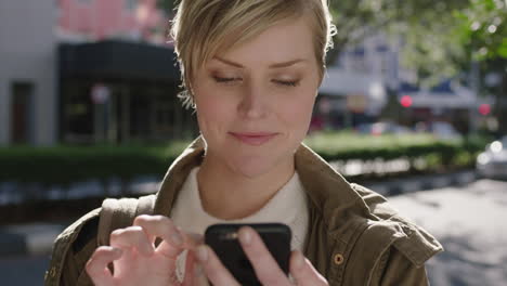 Retrato-De-Una-Hermosa-Mujer-Rubia-Parada-En-La-Acera-Enviando-Mensajes-De-Texto-Navegando-Usando-Un-Teléfono-Inteligente-Disfrutando-De-Un-Viaje