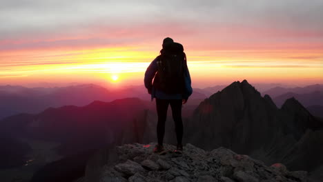 hiker on a mountain peak at sunset
