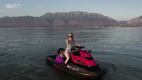 Gorgeous-Sexy-Woman-Modeling-on-Jet-Ski-Waverunner-on-Utah-lake,-Aerial