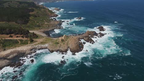 una vista aérea de las olas que se estrellan a lo largo de la escarpada costa de quintay, valparaíso, chile