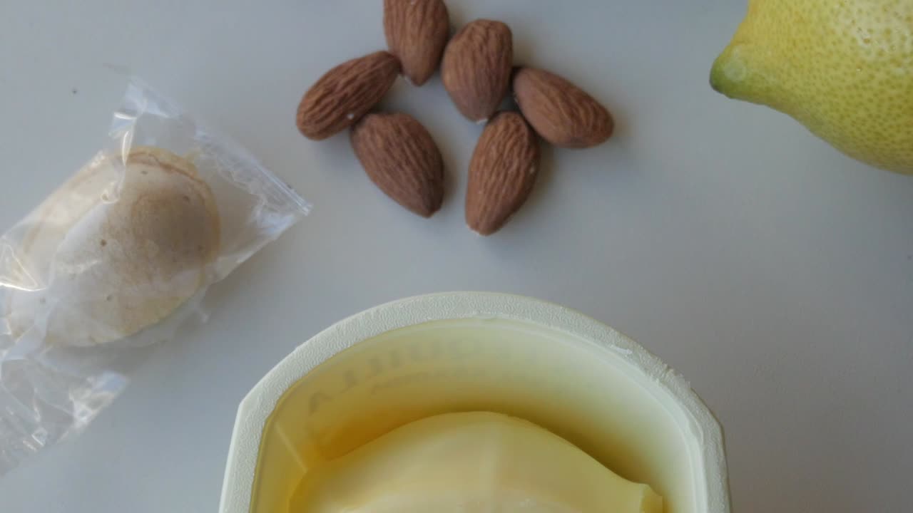 Forward view of almond, butter, lemon, vanilla and biscuits on a table